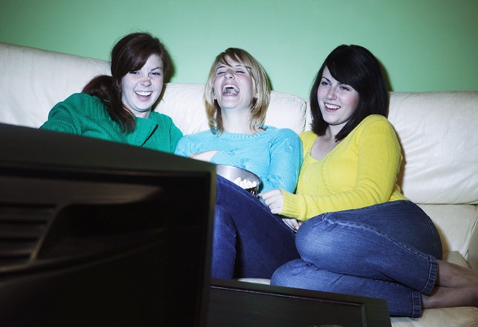 Three women watching television