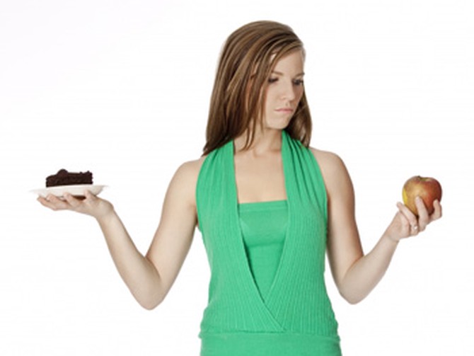 Woman deciding between eating healthy or bad
