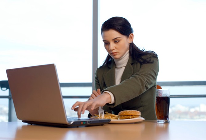 Businesswoman eating and working