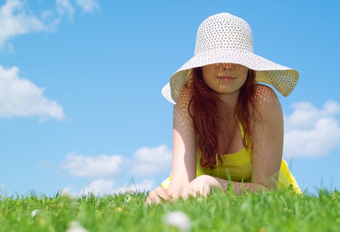 Woman in grass with sunhat on