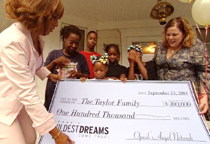 Connie Taylor with check from Oprah's Angel Network for new home