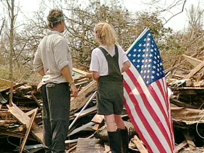 Jennifer sticks an American flag on what used to be her home.