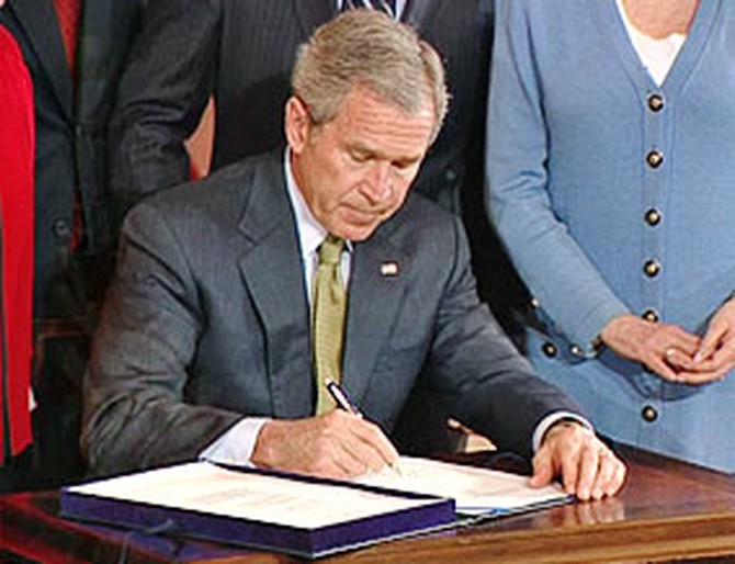 President Bush signs into law the Trafficking Victims Protection Reauthorization Act