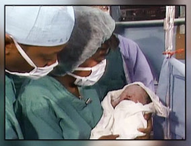 Oprah holds baby Vincent in the delivery room.