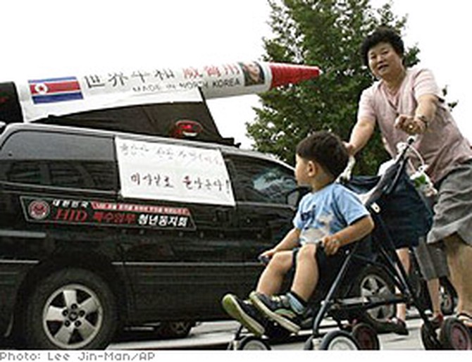 South Koreans pass a protest of North Korean missile launchers.