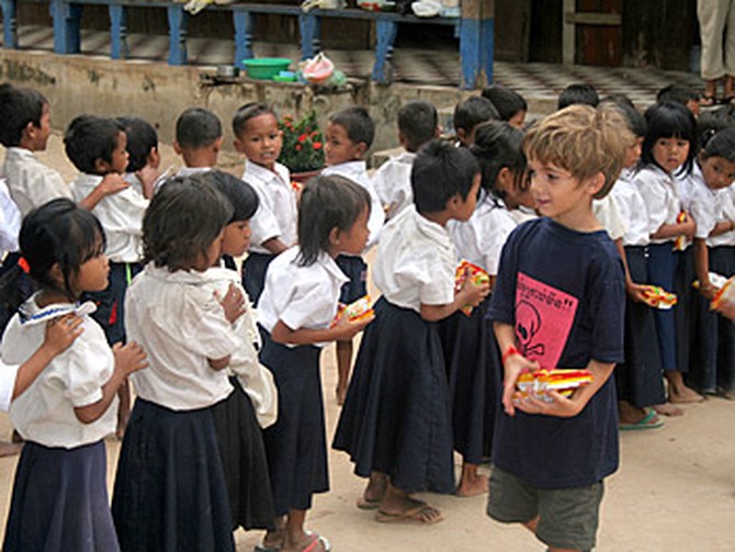 Kieran passes out food in Cambodia.