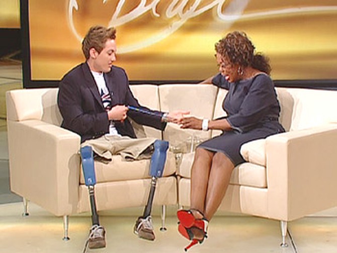 Rudy shows Oprah his Paralympic gold medal.