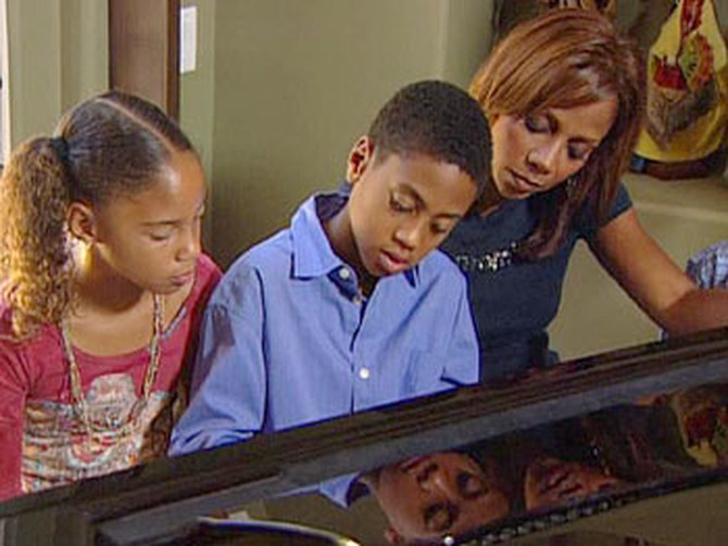 R.J. plays the piano for his mother and sister.