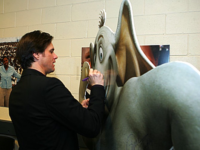 Jim Carrey signs a cutout of Horton.