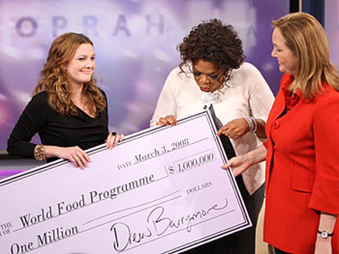 Drew Barrymore gives a donation to Josette Sheeran from the World Food Program.